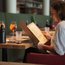 Woman reading menu in restaurant with drinks on the table