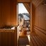 Sauna mit Holzinnenraum und Person im Bademantel auf Balkon mit Bergblick