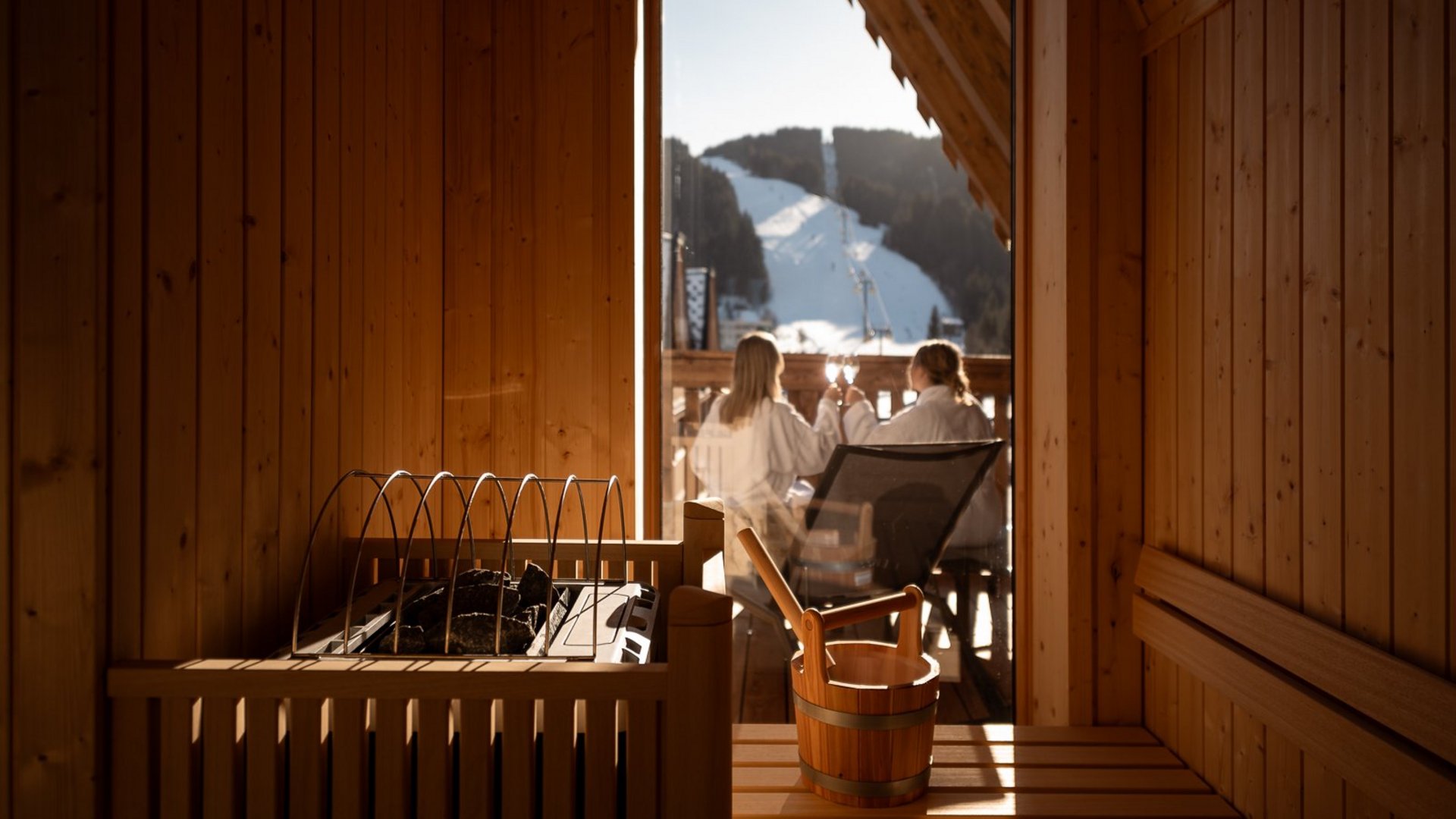 Innenansicht einer Sauna mit Blick auf zwei Frauen auf dem Balkon.